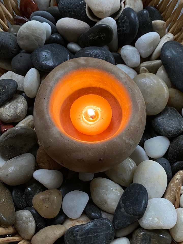 A collection of stones, with a candle rested on top of them.