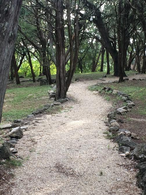 A gravel pathway, between trees.