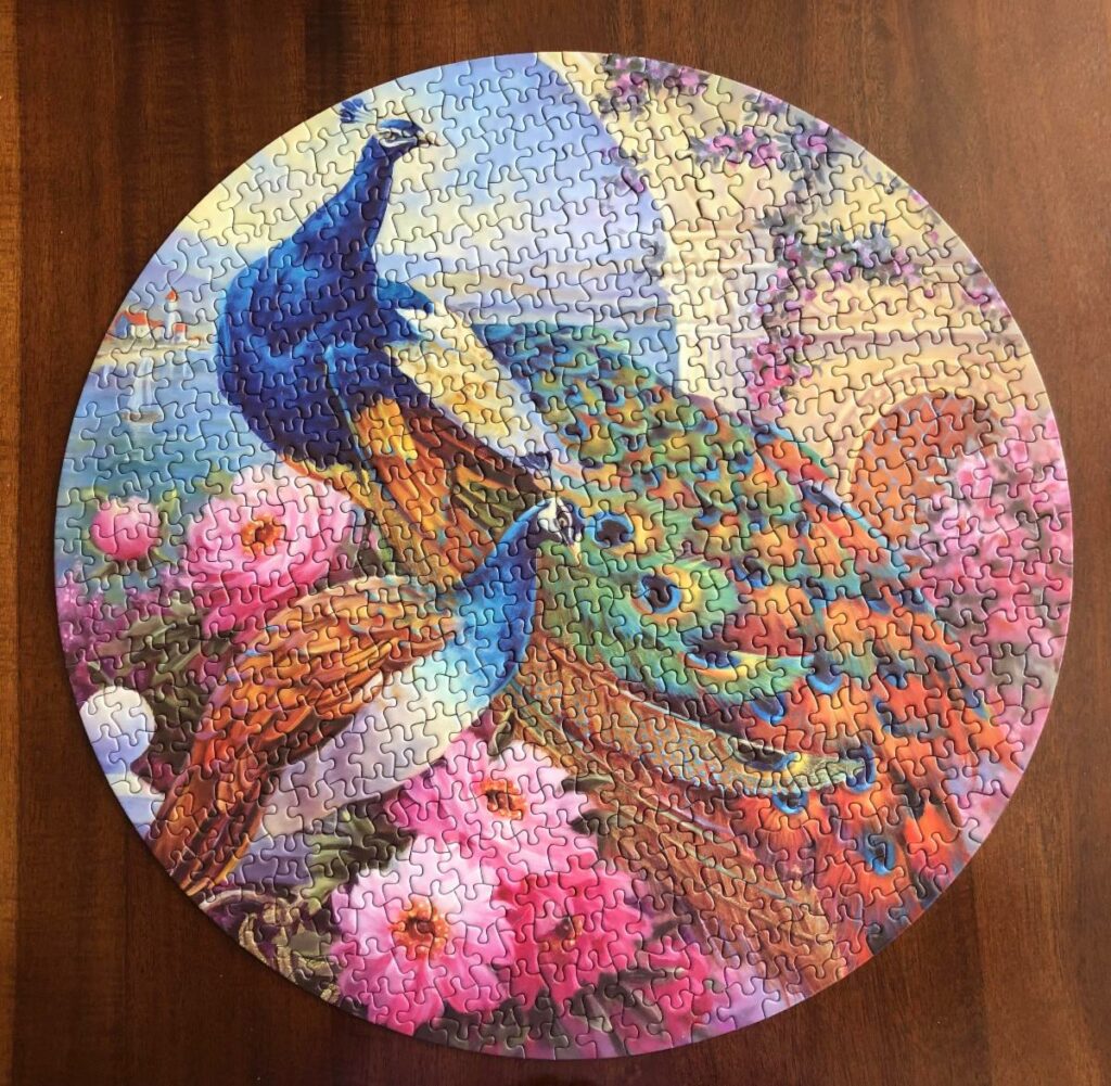 Round Jigsaw puzzle with two peacocks for the image.